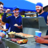 Group of Male Sports Fans Tailgating In Stadium Car Park
