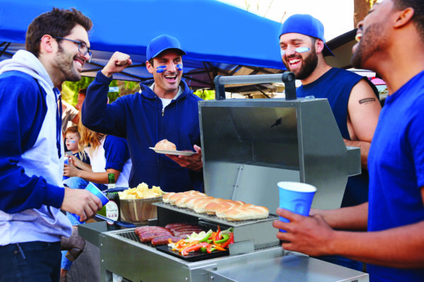 Group of Male Sports Fans Tailgating In Stadium Car Park